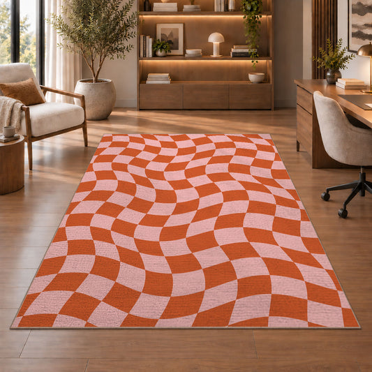 Wavy Orange and Pink Checkerboard area rug in a study with an armchair and bookshelves