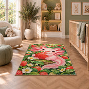 Axolotl Strawberry Rug in a nursery with a crib and armchair