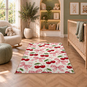 Cherry and Bow Pattern Rug in a nursery with a crib and armchair