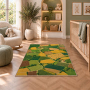 Patchwork Farm Fields Aerial rug in a nursery with a crib and armchair