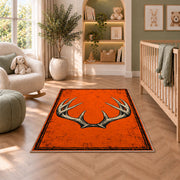 Blaze Orange Antlers rug in a nursery with a crib and armchair