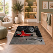 Car jack and spare tire rug in a nursery with a crib and armchair