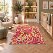 Pink cowgirl rug in a nursery with a crib and armchair
