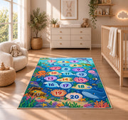 Blue ocean hopscotch rug with numbered bubbles, coral, fish and sea animals, displayed across a wood floor