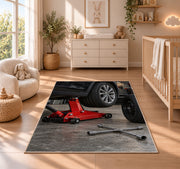 Car jack and spare tire rug in a nursery beside a crib and dresser
