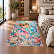 Baby Mermaid and Dolphin Nursery Rug in a bedroom beside the bed