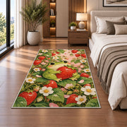 frog hugging a strawberry rug in a bedroom beside the bed