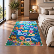 Blue ocean hopscotch rug with numbered bubbles, coral, fish and sea animals, shown from an angled room perspective