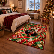 A smiling elf clutches a wrapped present while sitting inside a red and green spiral; rug shown in a Christmas bedroom