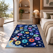 Navy galaxy hopscotch rug with colorful numbered planets, a rocket and astronaut, placed on a wood floor near furniture