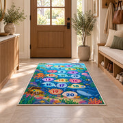 Blue ocean hopscotch rug with numbered bubbles, coral, fish and sea animals, displayed in a cozy home interior