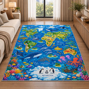 Blue world map rug with ocean animals and colorful coral in a sunlit lounge beside a sofa