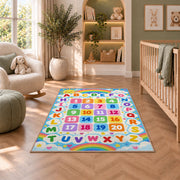 rainbow alphabet and numbers rug displayed in a nursery beside an upholstered chair