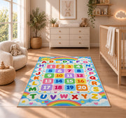 rainbow alphabet and numbers rug displayed in a nursery beside a crib