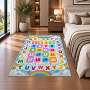 rainbow alphabet and numbers rug displayed in a bedroom beside the bed