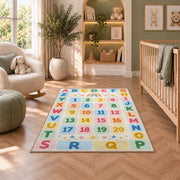 pastel alphabet number grid rug displayed in a nursery beside an upholstered chair