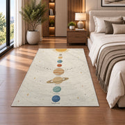 pastel planet orbit learning rug displayed in a bedroom beside the bed