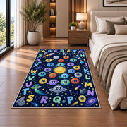 space alphabet number trail rug displayed in a bedroom beside the bed