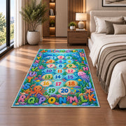 ocean alphabet number trail rug displayed in a bedroom beside the bed