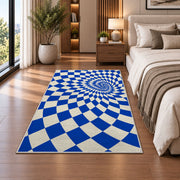 Blue Optical Checker Vortex area rug in a bedroom beside the bed