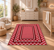 Red and Pink Checkered Border area rug in a nursery beside a crib