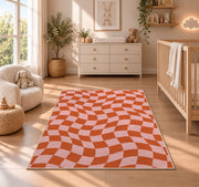 Wavy Orange and Pink Checkerboard area rug in a nursery beside a crib