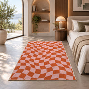 Wavy Orange and Pink Checkerboard area rug in a bedroom with an arched window