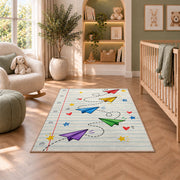 Paper Planes on Notebook Paper area rug in a nursery with a crib and armchair