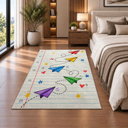 Paper Planes on Notebook Paper area rug in a bedroom beside the bed
