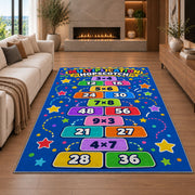 Multiplication Hopscotch Rug shown in a living room with a fireplace