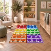 Rainbow Shapes Color Chart Rug shown in a nursery with a cot and soft toys