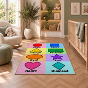 Pastel Shapes Learning Rug shown in a nursery with a cot and soft toys