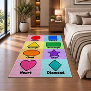 Pastel Shapes Learning Rug shown beside a bed with neutral bedding