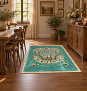 Hunting and fishing emblem area rug in teal, cream, brown, and black, close decorative detail
