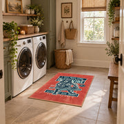 Skull mechanic workshop area rug in red, teal, cream, and black, wide interior view