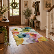 Pastel watercolor floral area rug in pink, yellow, green, blue, and lavender, close decorative detail