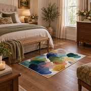Pastel abstract pebble area rug in teal, navy, coral, yellow, and blush, cozy home setting