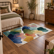 Pastel abstract pebble area rug in teal, navy, coral, yellow, and blush, soft surface detail