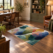 Pastel abstract pebble area rug in teal, navy, coral, yellow, and blush, wood floor styling