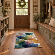 Pastel abstract pebble area rug in teal, navy, coral, yellow, and blush, wide interior view