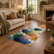 Pastel abstract pebble area rug in teal, navy, coral, yellow, and blush, design detail view