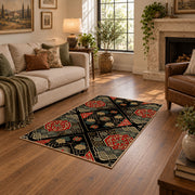 Black patchwork medallion area rug in red, beige, gold, and charcoal, design detail view