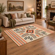 Cream and orange tribal diamond area rug with black and gray accents, angled room view