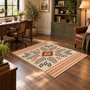 Cream and orange tribal diamond area rug with black and gray accents, soft surface detail