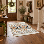 Cream and blue folk floral area rug with orange botanical details, close decorative detail