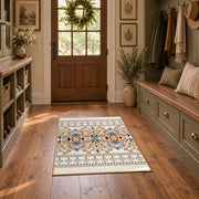 Cream and blue folk floral area rug with orange botanical details, wide interior view