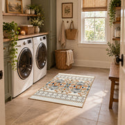 Cream and blue folk floral area rug with orange botanical details, design detail view