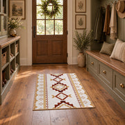 Cream and rust tribal area rug with brown and gold diamond motifs, front room mockup