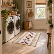 Cream and rust tribal area rug with brown and gold diamond motifs, wide interior view