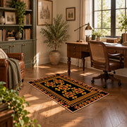 Black and orange tribal area rug with bold geometric border motifs, complete product view